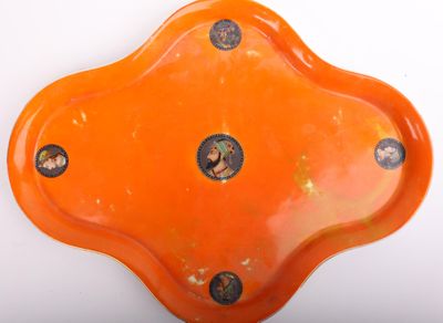 une assiette orange percée de trous posée sur un fond blanc