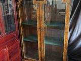 a wooden cabinet with two glass doors and a red cabinet