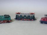 trois petits trains assis côte à côte sur une surface blanche