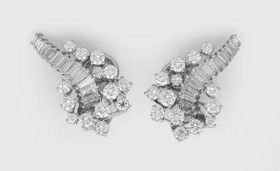 a pair of diamond earrings on a white background