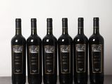 six bouteilles de vin sont alignées sur une table en bois