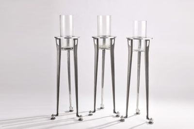 three tall glass candles are sitting on top of each other