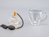 un verre et un petit flacon de parfum posés sur une table