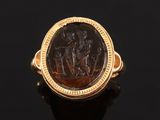a gold ring with an image of a man and woman on a horse
