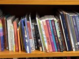 a wooden book shelf with many books on it