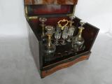bottles and glasses in a wooden box on a white surface