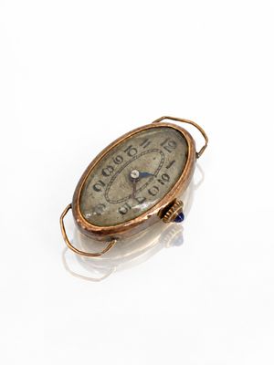 un gros plan d'une petite horloge posée sur une surface blanche