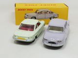 two toy cars sitting next to each other in front of a box