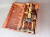 une boîte en bois contenant un microscope, posée sur une table