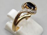 a close up of a gold ring with a sapphire stone and diamonds