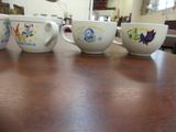 four cups that have different designs on them on a table
