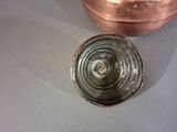 a metal container with a lid sitting on a table