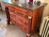a wooden dresser with a marble top in a room with a radiator