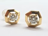 une paire de boucles d'oreilles en diamant sur une surface blanche