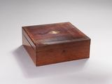 une petite boîte en bois avec un couvercle sur une surface blanche