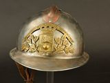 a silver helmet with a gold emblem on it