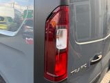 the rear end of a grey van parked in a parking lot