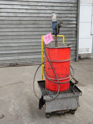 a red barrel sitting on a cart with a sign on it