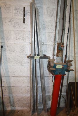 a red pole in the middle of a room next to a white brick wall