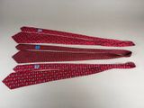 three red ties with blue and white designs on them on a white surface