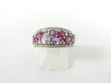 un gros plan d'une bague ornée de pierres roses et violettes