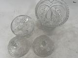 three clear glass bowls and a bowl on a white surface