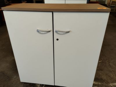 une armoire blanche à deux portes avec un plan de travail en bois
