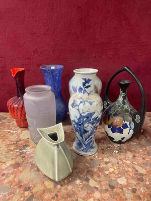 many different vases sitting on a table with a red wall in the background