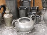 a lot of silver vases and other metal objects on the floor