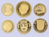 six gold coins of different countries are shown on a white surface
