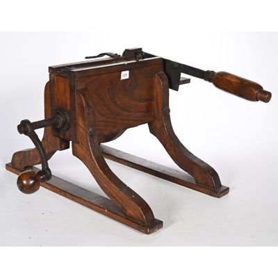 une vieille machine en bois munie d'une poignée en bois, sur fond blanc