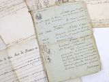 several old papers are stacked on top of each other on a table