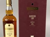 une bouteille de whisky posée sur une table à côté d'un coffret