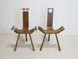 pair of wooden chairs sitting on top of a white floor next to a wall
