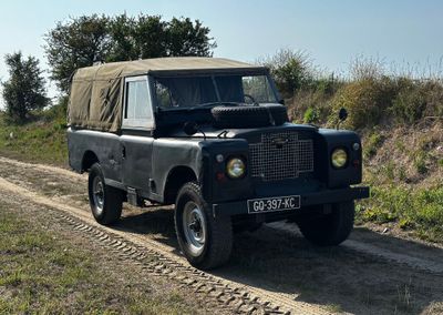 une Land Rover noire roulant sur un chemin de terre