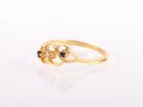 a close up of a gold ring with black stones