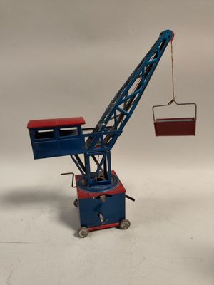 une grue miniature qui tient une boîte dans sa main