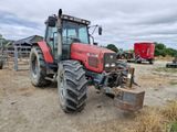a red tractor that is parked in the dirt
