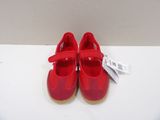 pair of red children ' s shoes sitting on a white surface