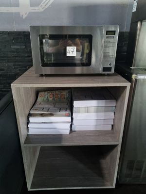 a microwave that is sitting on a shelf in a kitchen