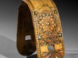 a close up of a wooden bracelet with a flower design