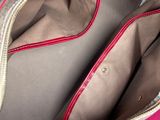 a purse that is open on a pink surface