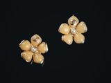une paire de boucles d'oreilles en forme de fleurs jaunes sur fond noir