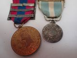 two medals and a medal are sitting on a white surface
