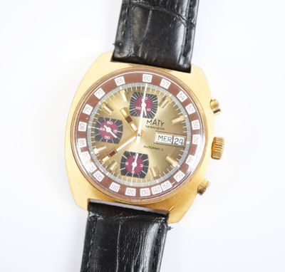 une montre en or avec un bracelet en cuir noir posée sur un fond blanc
