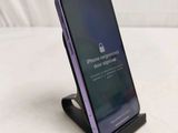 an iphone sitting on top of a stand with a lock on the screen