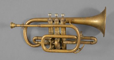 an old brass trumpet with two valves on a gray surface