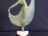 statue of a woman in a flowing dress on a marble base