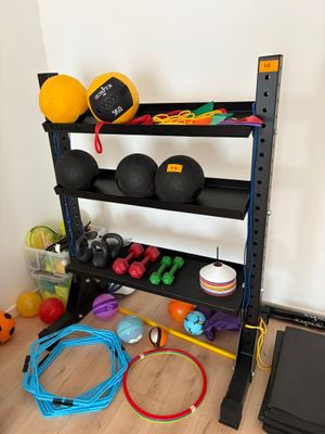 une photo d'un support pour matériel de gym avec des ballons et d'autres accessoires