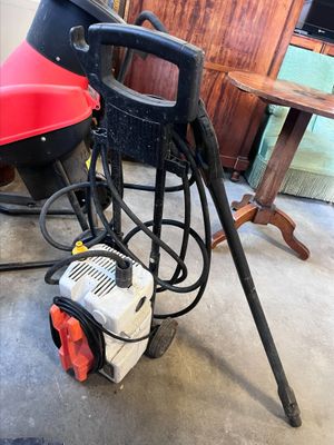 une machine rouge et noire posée par terre à côté d'une table
